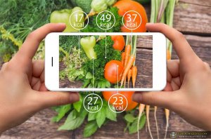 Smartphone In Hand With Information Of Calories In Vegetables.