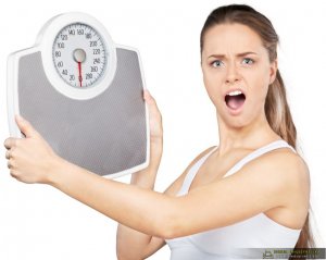 Portrait Of An Surprised Woman Holding A Weight Scale